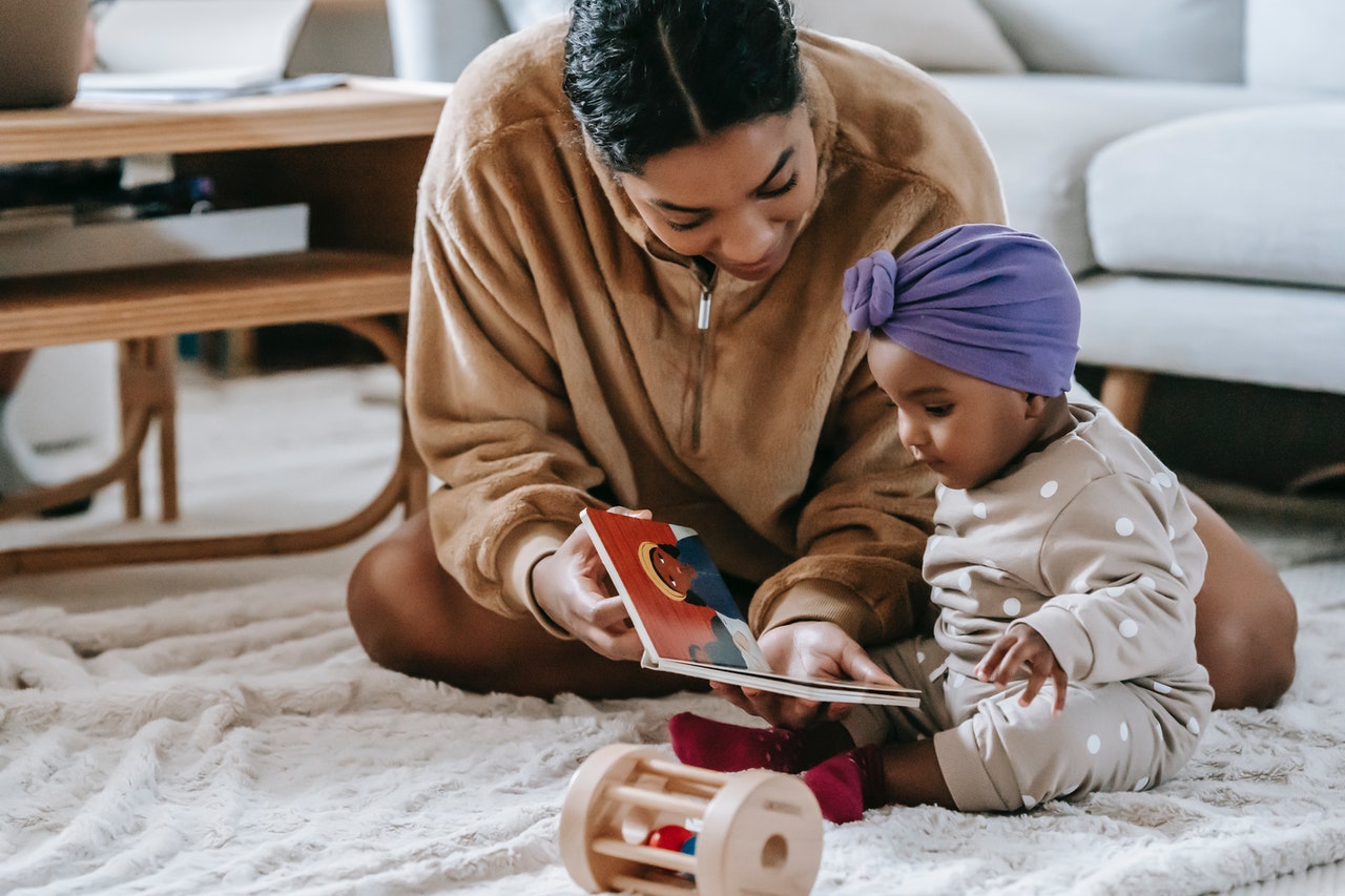 Infant reading with mother